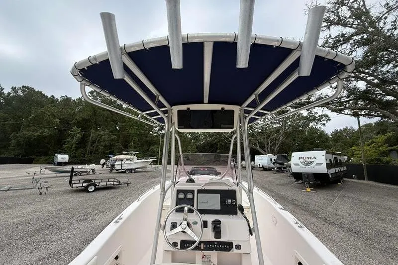 Slide: The Image of 2005 Grady-White Escape 209 boat interior with steering wheel and canopy in a parking area. - 8
