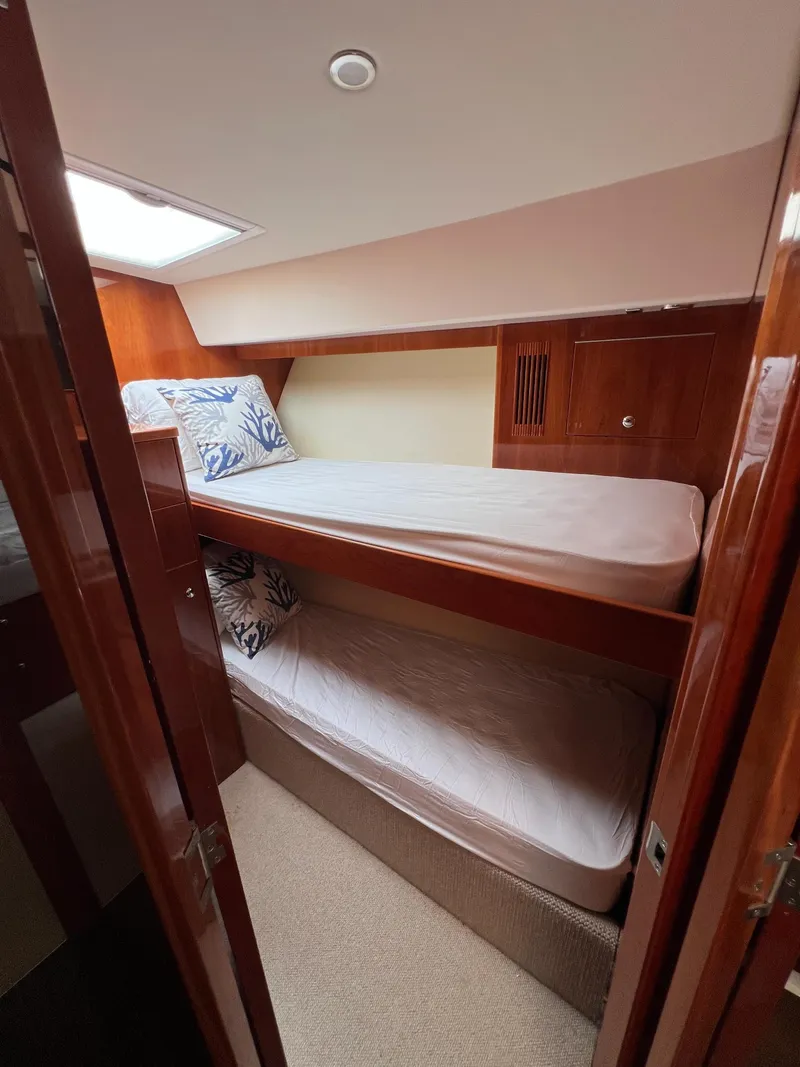 Slide: The Image of Bunk beds in 2016 Riviera 45 OPEN yacht cabin with wooden interior. - 13