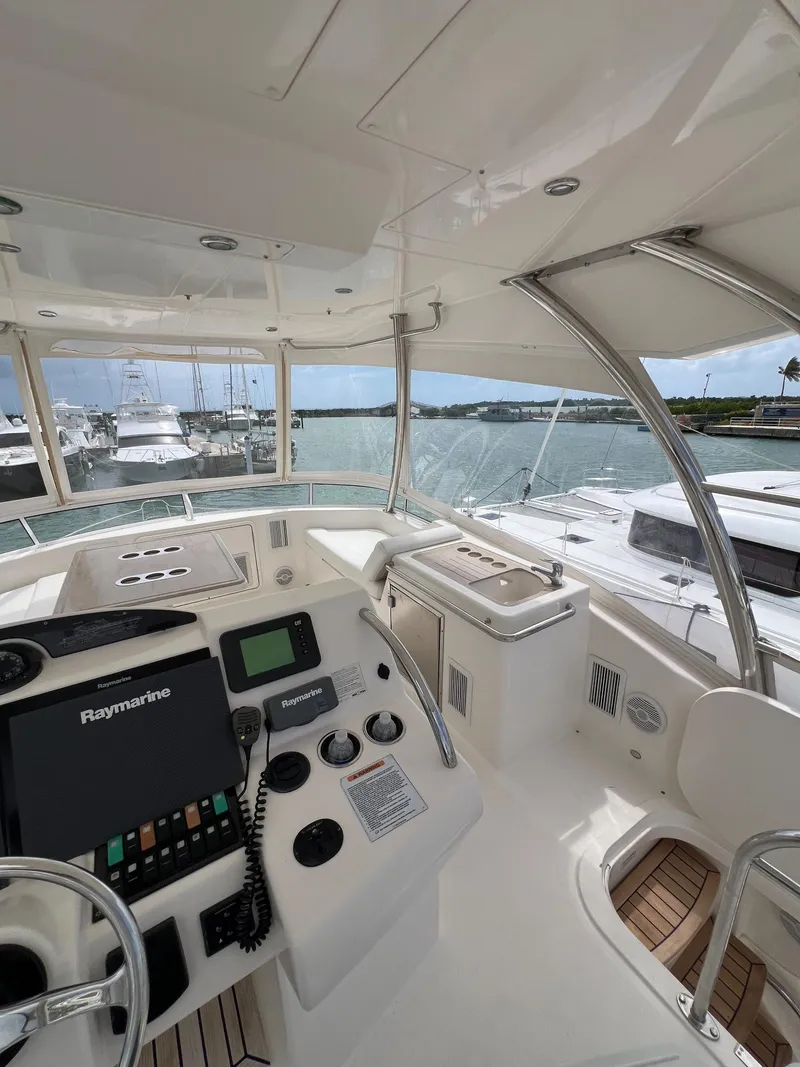 Slide: The Image of 2016 Riviera 45 OPEN yacht cockpit with navigation controls, docked at marina. - 21
