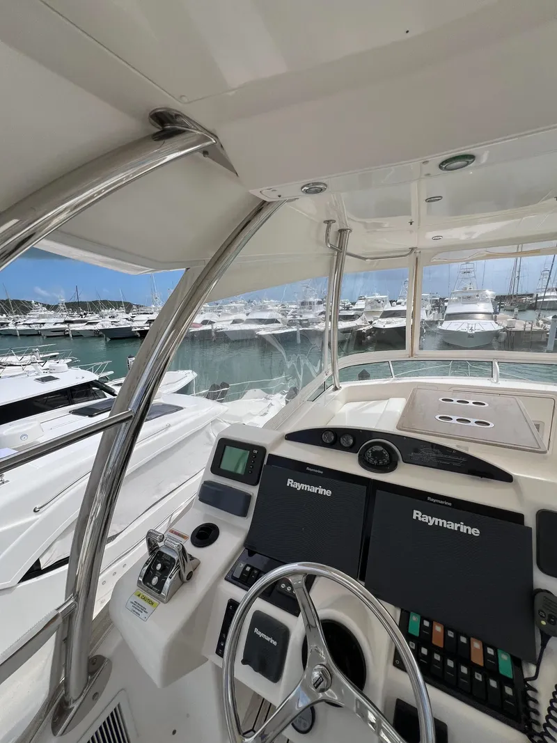 Slide: The Image of Riviera 45 OPEN 2016 yacht helm with marina view, featuring Raymarine navigation systems. - 22