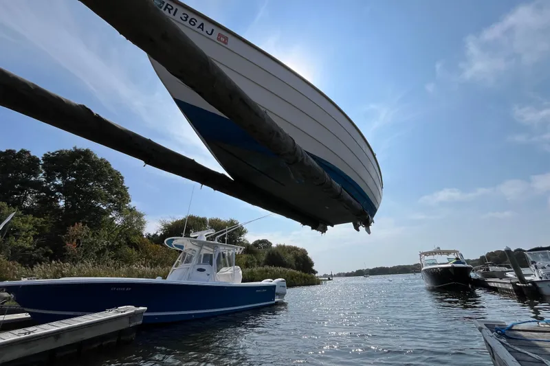 Slide: The Image of 1986 Stur-Dee 16 Dory boat suspended above water at a marina. - 12