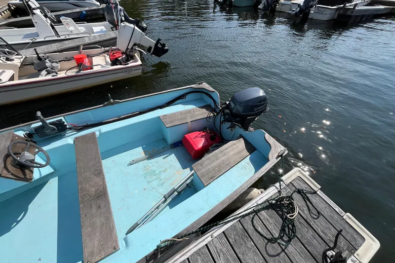 Slide: The Image of 1986 Stur-Dee 16 Dory boat docked, featuring a Yamaha outboard motor. - 4