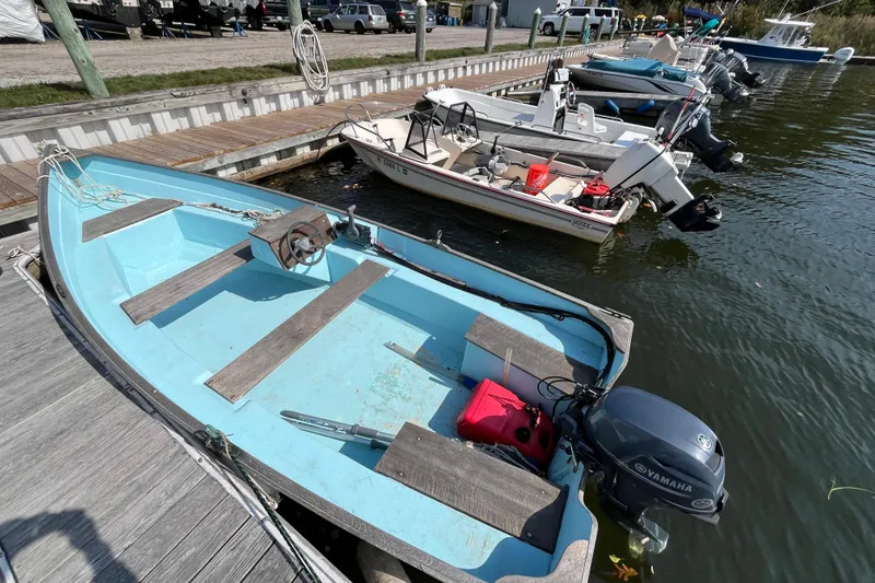 Slide: The Image of 1986 Stur-Dee 16 Dory boat docked with Yamaha outboard motor, blue interior. - 6