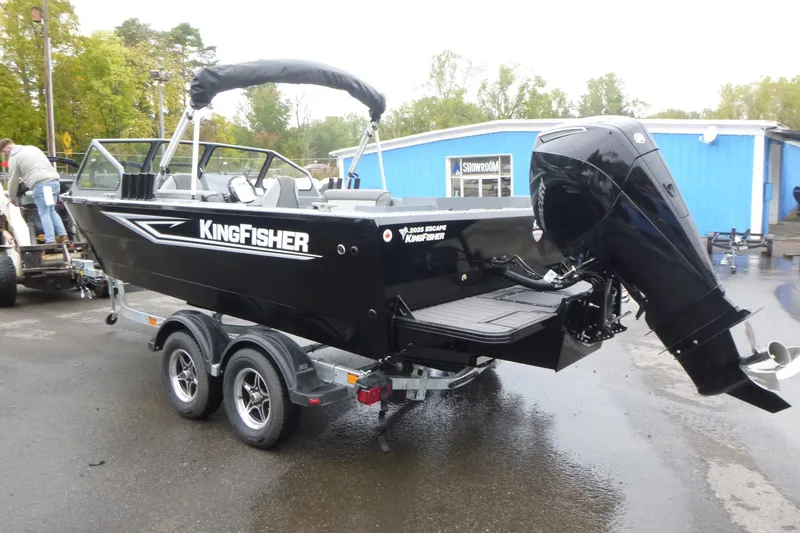 Slide: The Image of 2026 KingFisher 2025 Escape boat on trailer, parked outdoors near blue building. - 5