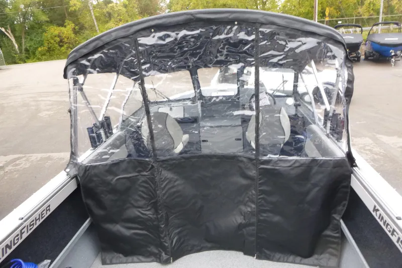 Slide: The Image of KingFisher 2025 Escape boat with protective canopy, 2026 model, parked outdoors. - 6