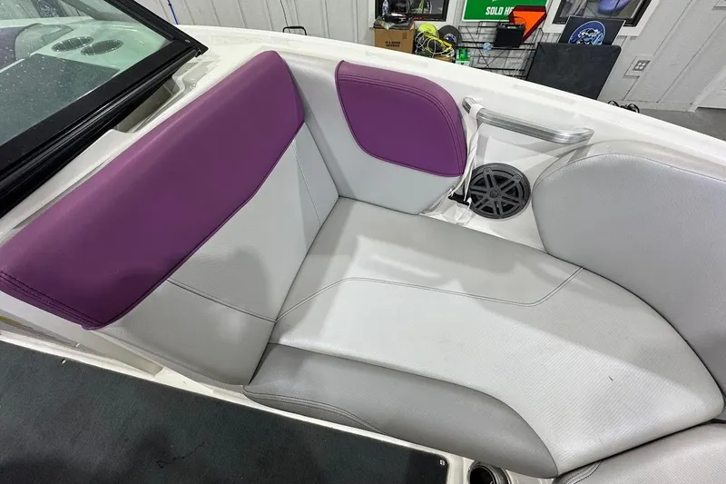 Slide: The Image of 2016 MasterCraft NXT22 boat interior with purple and white seating, speaker, and cup holder. - 14