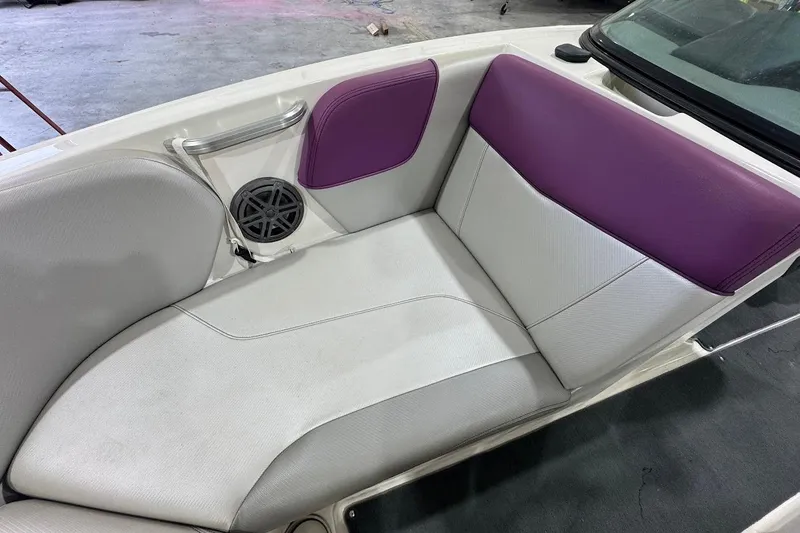 Slide: The Image of 2016 MasterCraft NXT22 boat interior with white and purple seating, featuring a speaker. - 15
