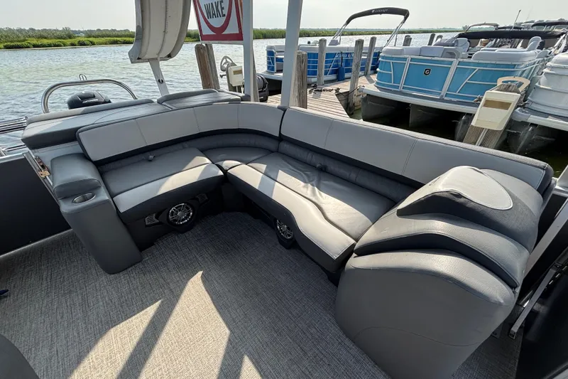 Slide: The Image of 2023 TAHOE AVALON Cascade boat interior with plush seating at a dock. - 10