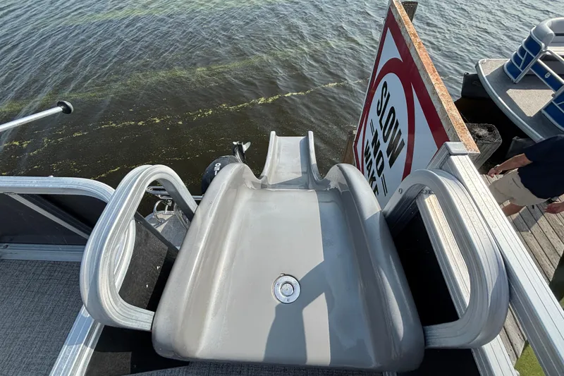 Slide: The Image of 2023 TAHOE AVALON Cascade boat with slide, docked near "Slow No Wake" sign. - 12