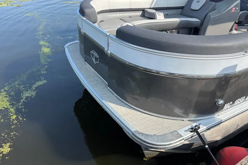 Slide: The Image of 2023 TAHOE AVALON Cascade pontoon boat on calm water with algae. - 2