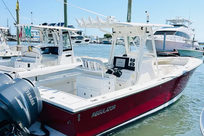 The Image of 2003 Regulator 26 Center Console boat docked, featuring Yamaha outboard engines. - 1