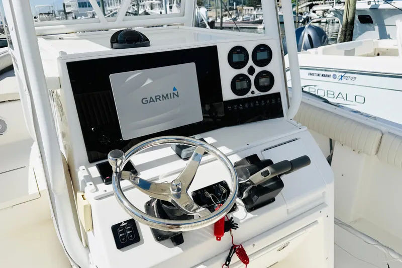 Slide: The Image of 2003 Regulator 26 Center Console boat dashboard with Garmin navigation system and steering wheel. - 10
