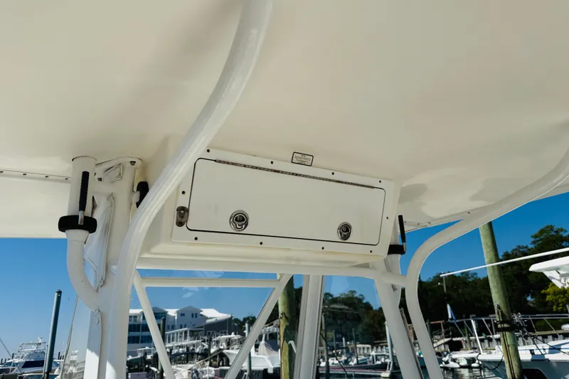 Slide: The Image of 2003 Regulator 26 Center Console boat, T-top storage compartment, marina background. - 11