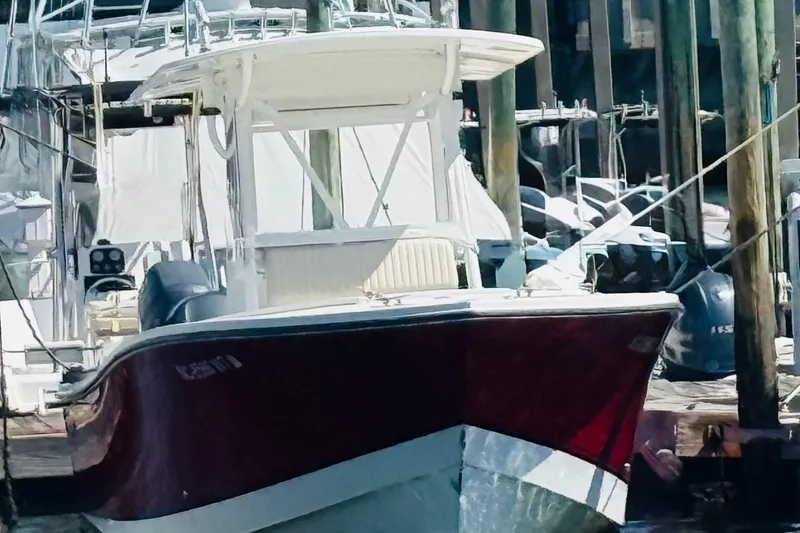 Slide: The Image of 2003 Regulator 26 Center Console boat docked at a marina. - 3