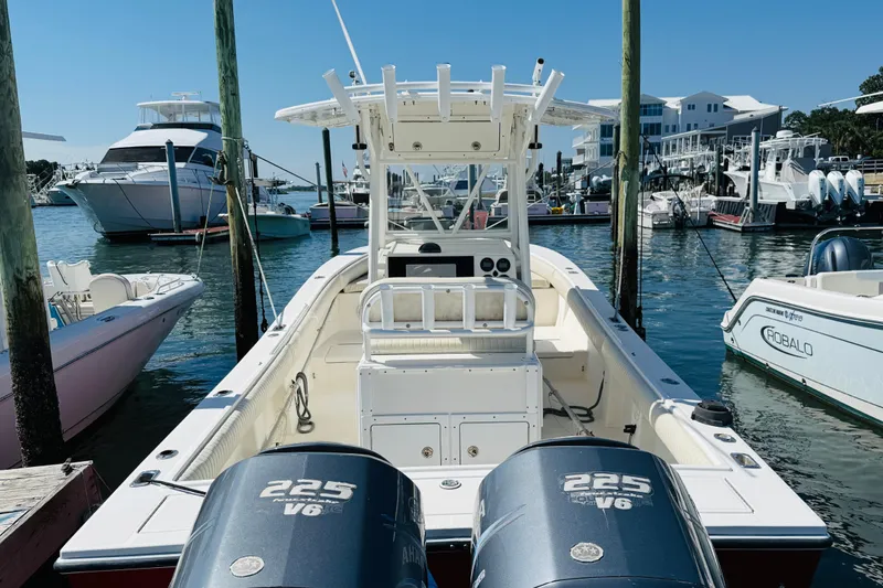Slide: The Image of 2003 Regulator 26 Center Console boat docked at marina with twin 225 V6 engines. - 5