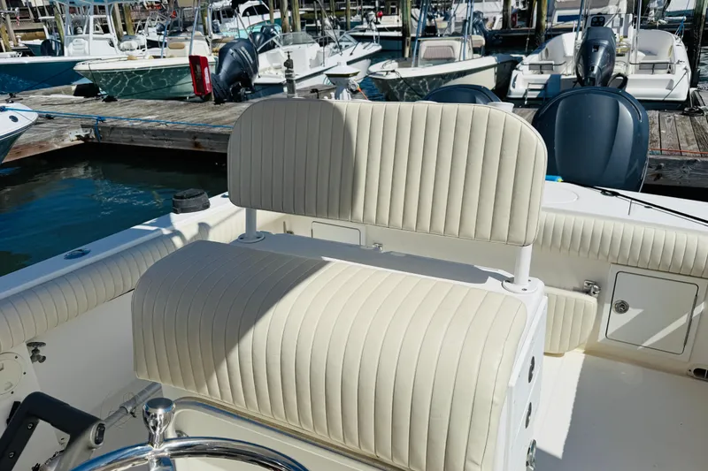 Slide: The Image of 2003 Regulator 26 Center Console boat interior with cream seating at marina. - 8