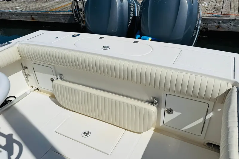 Slide: The Image of 2003 Regulator 26 Center Console boat interior with cushioned seating and storage compartments. - 9