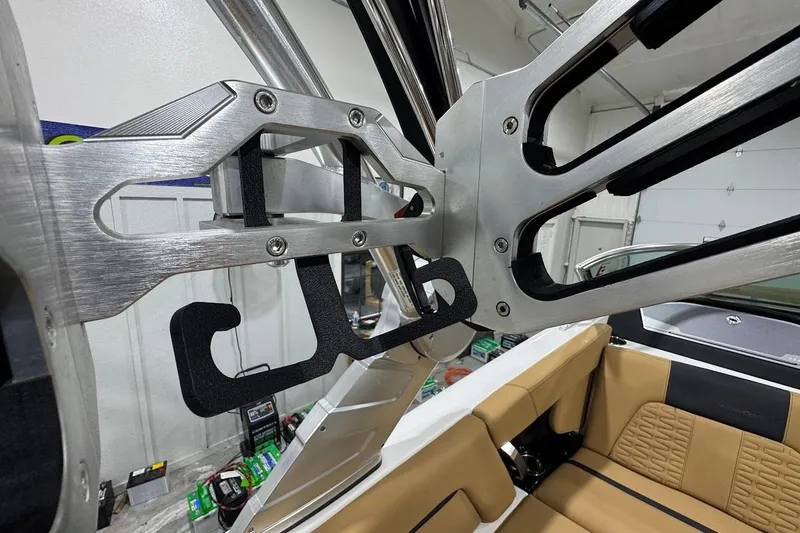 Slide: The Image of 2021 MasterCraft X24 boat interior with metal wakeboard rack and tan seating. - 18