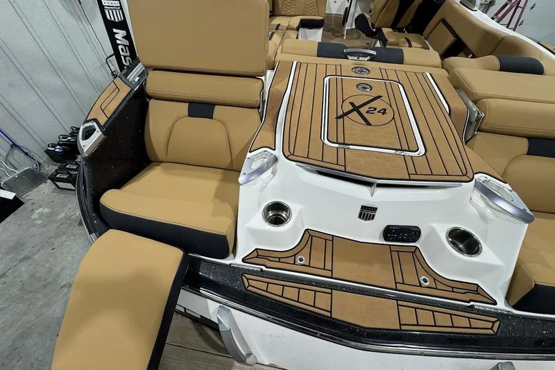 Slide: The Image of 2021 MasterCraft X24 boat interior with tan and black seating, stylish deck design. - 7