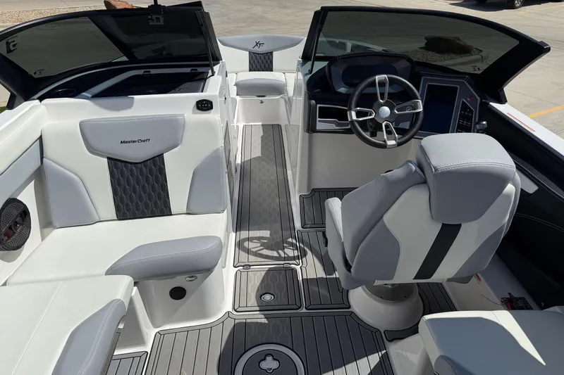 Slide: The Image of 2023 MasterCraft XT24 boat interior with sleek seating and modern dashboard design. - 11