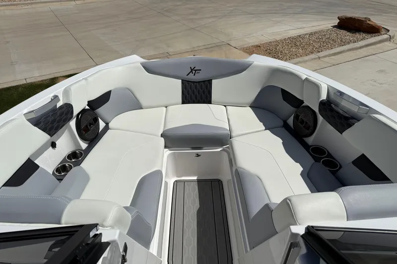 Slide: The Image of 2023 MasterCraft XT24 boat interior with white seating and cup holders. - 12