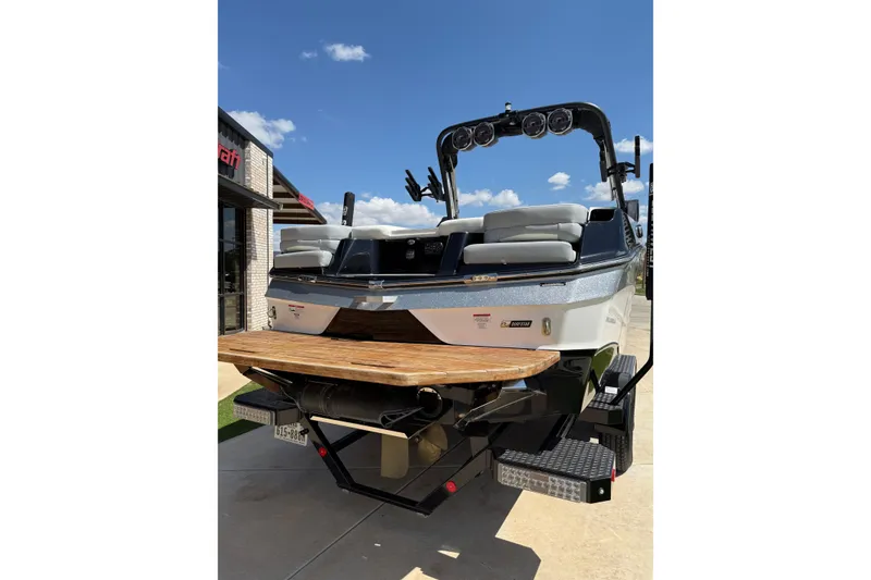 Slide: The Image of 2023 MasterCraft XT24 boat with sleek design and wooden swim platform. - 4