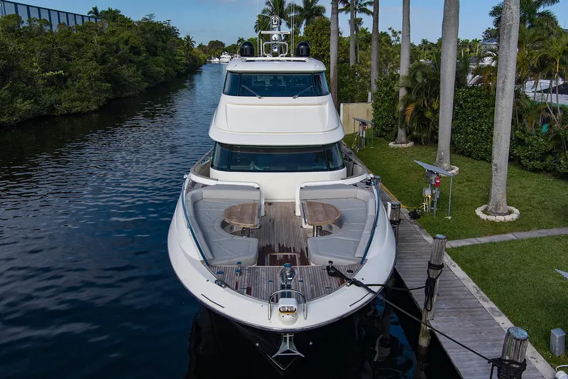 Slide: The Image of 2021 Monte Carlo Yachts MCY 76 Skylounge docked in a scenic canal setting. - 2