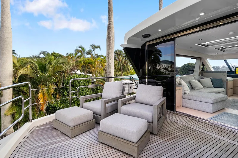 Slide: The Image of Luxurious 2021 Monte Carlo Yachts MCY 76 Skylounge with elegant outdoor seating and lush surroundings. - 23