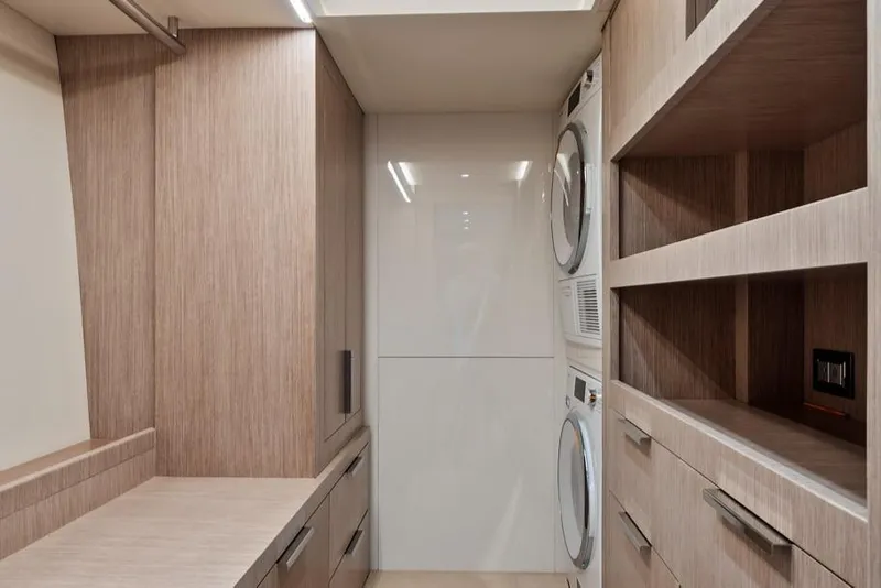 Slide: The Image of Laundry room in 2021 Monte Carlo Yachts MCY 76 Skylounge with modern appliances and wood cabinetry. - 28