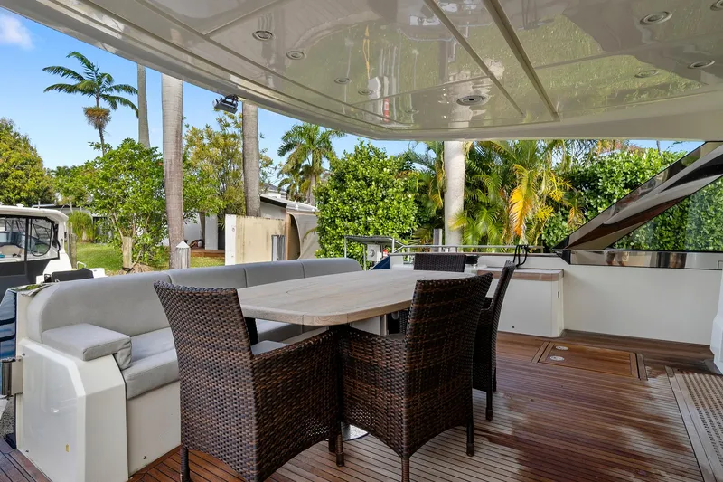 Slide: The Image of Outdoor seating area on 2021 Monte Carlo Yachts MCY 76 Skylounge, featuring wicker chairs and table. - 5