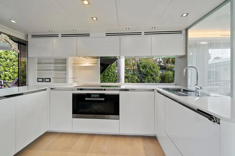 Slide: The Image of Modern kitchen in 2021 Monte Carlo Yachts MCY 76 Skylounge, featuring sleek white cabinetry. - 7