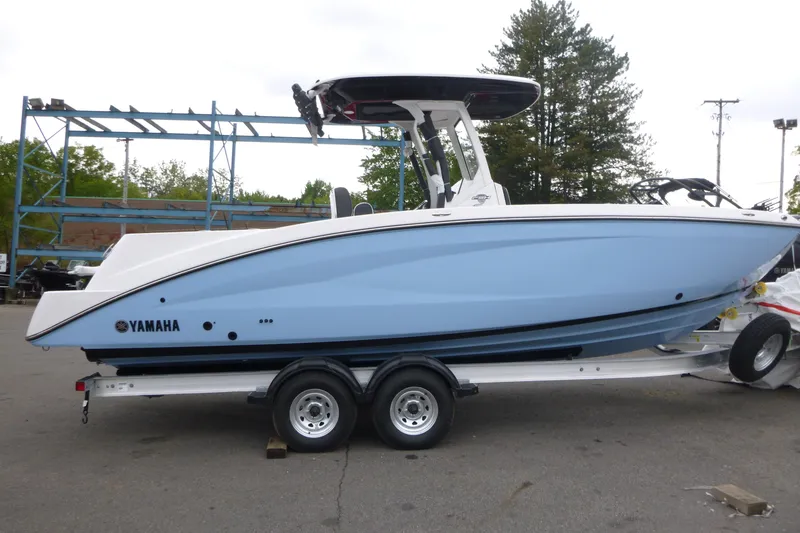 The Image of 2026 Yamaha Boats 255 FSH Sport H on trailer, side view, light blue hull. - 1