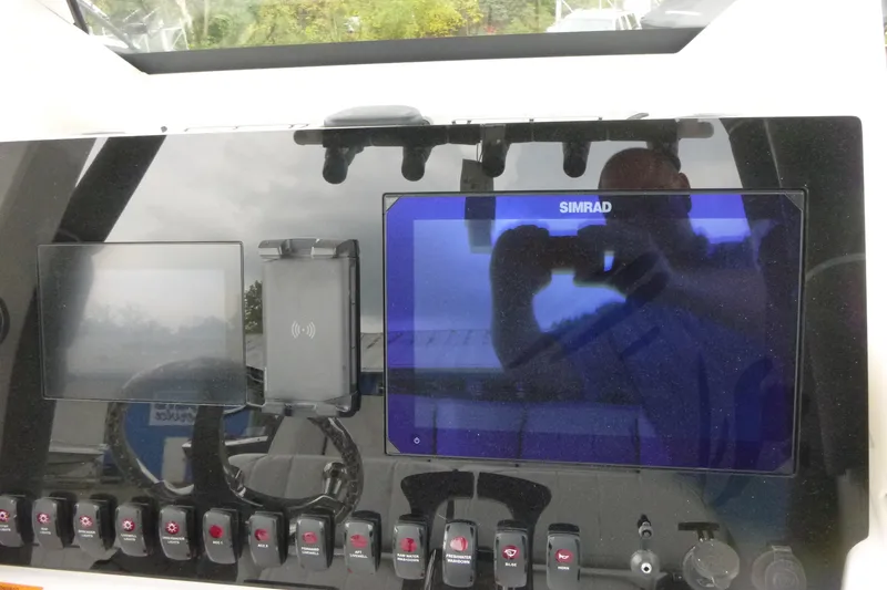 Slide: The Image of Control panel of 2026 Yamaha Boats 255 FSH Sport H with Simrad display and switches. - 14