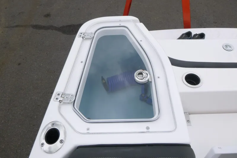 Slide: The Image of 2026 Yamaha Boats 255 FSH Sport H deck with storage compartment and visible hose. - 17