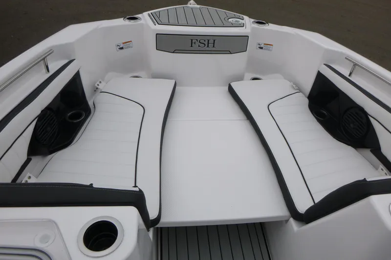 Slide: The Image of 2026 Yamaha Boats 255 FSH Sport H interior with white cushioned seating and cup holders. - 6