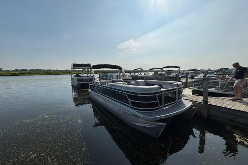 The Image of Pontoon boats docked at a marina, featuring a 2025 Godfrey SW2286MT model. - 0