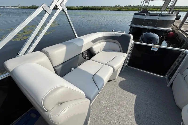 Slide: The Image of Luxury seating on a 2025 Godfrey SW2286MT pontoon boat by the water. - 11