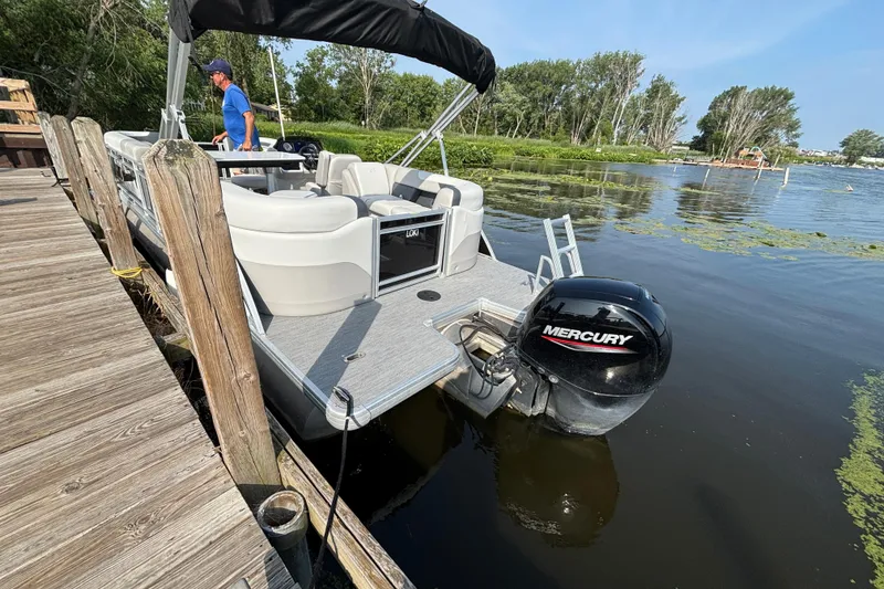 Slide: The Image of 2025 Godfrey SW2286MT pontoon boat docked with Mercury outboard motor. - 3