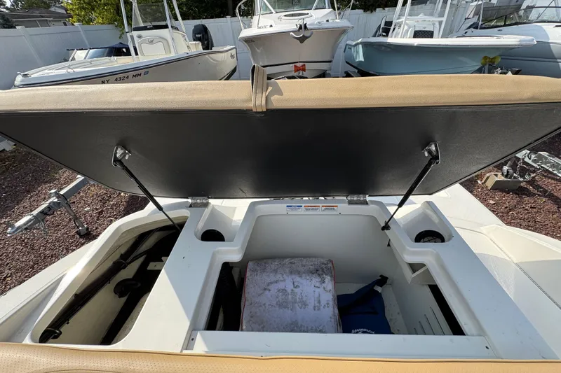 Slide: The Image of 2021 Sea Ray SPX 190 Outboard boat with open storage compartment, docked outdoors. - 21