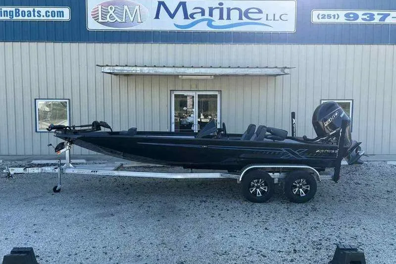 Slide: The Image of 2026 Xpress H20 Bass boat on trailer outside L&M Marine dealership. - 1