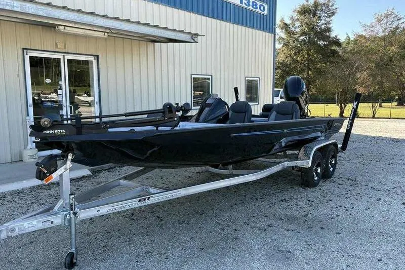 Slide: The Image of 2026 Xpress H20 Bass boat on trailer outside a building. - 4