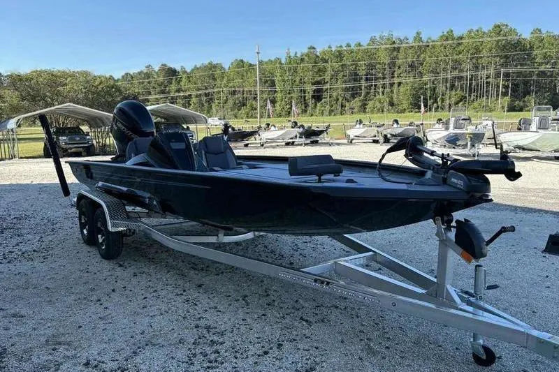 Slide: The Image of 2026 Xpress H20 Bass boat on trailer, parked outdoors with trees in background. - 7