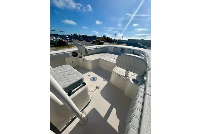 Slide: The Image of 2026 Carolina Skiff 22 Ultra Elite boat interior with cushioned seating under a clear blue sky. - 4
