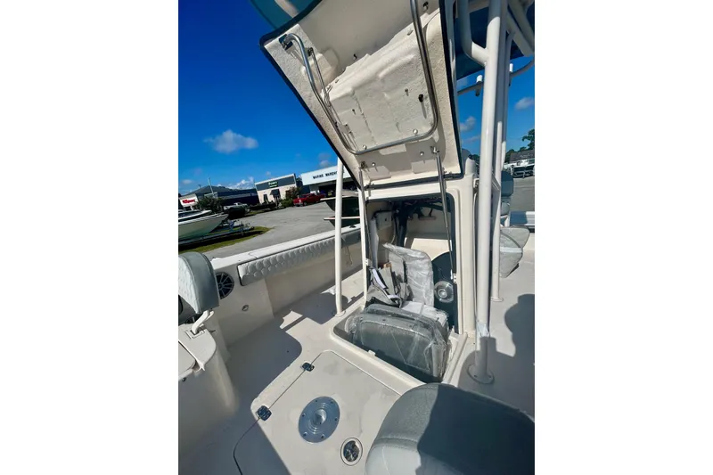 Slide: The Image of 2026 Carolina Skiff 22 Ultra Elite boat interior with open storage compartment, under clear blue sky. - 5