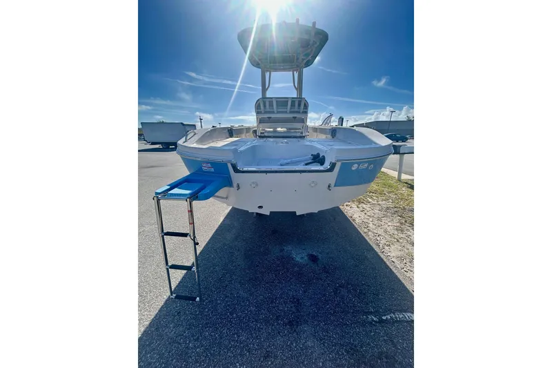 Slide: The Image of 2026 Carolina Skiff 22 Ultra Elite boat with ladder, parked under a sunny sky. - 8