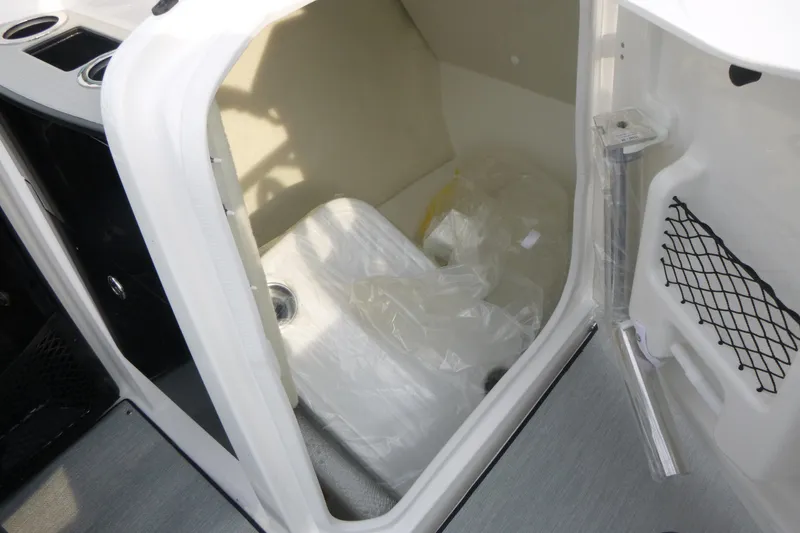 Slide: The Image of 2026 Yamaha Boats AR250 interior storage compartment with netted pocket and cup holders. - 8