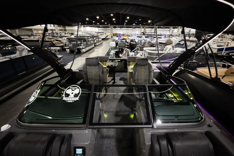 Slide: The Image of 2026 Godfrey SanPan 25' Split Bench Windshield boat displayed at an indoor showroom. - 11