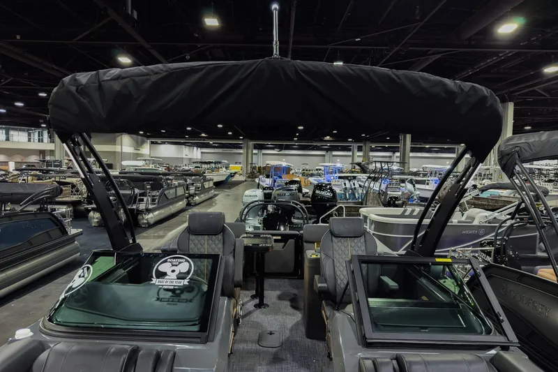 Slide: The Image of 2026 Godfrey SanPan 25' Split Bench Windshield boat displayed at an indoor showroom. - 12