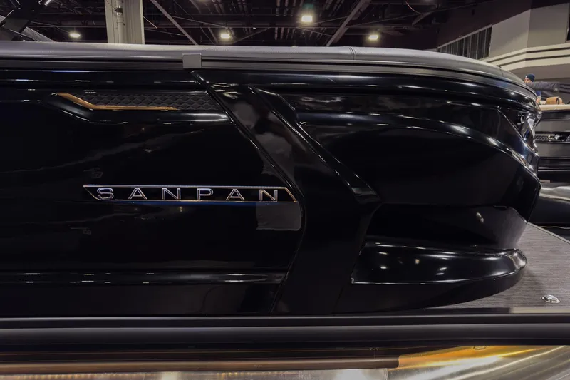 Slide: The Image of 2026 Godfrey SanPan 25' Split Bench Windshield boat, sleek black design, showcased indoors. - 2