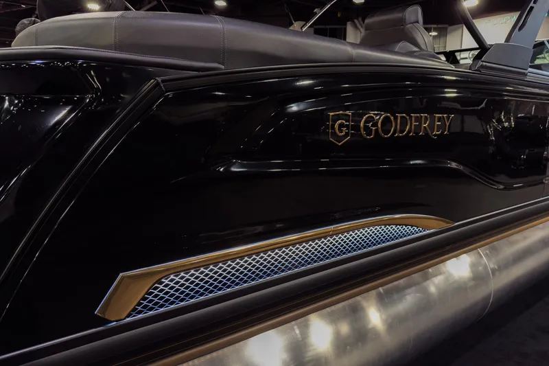 Slide: The Image of 2026 Godfrey SanPan 25' Split Bench Windshield boat, sleek black design with logo detail. - 3
